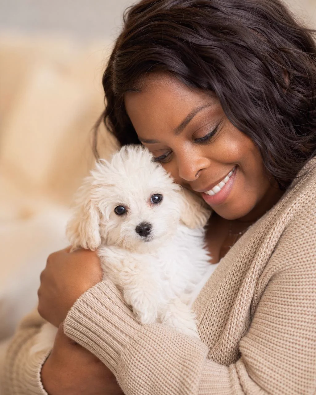 Lu's Pups founder cuddling a small poodle puppy